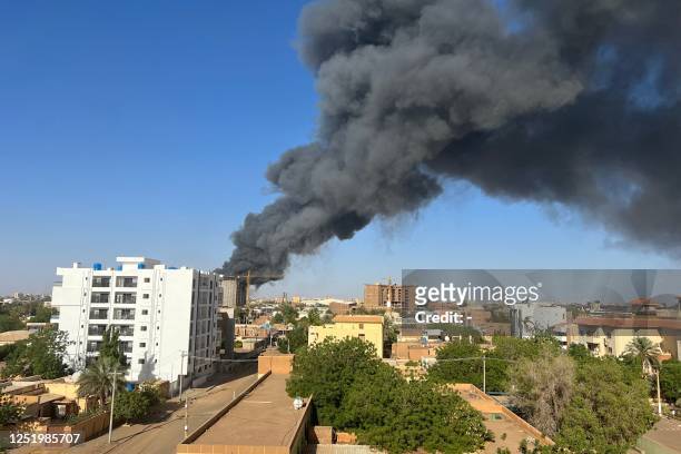 Column of smoke rises behind buildings near the airport area in Khartoum on April 19 amid fighting between the army and paramilitaries following the...