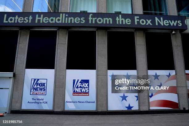 Headlines scroll at the Twenty-First Century Fox Inc headquarters in the Manhattan borough in New York on April 19, 2023. - Fox News averted a...