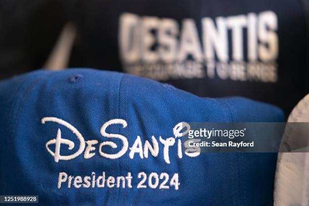 Baseball caps promoting Florida Governor Ron DeSantis sit on a table before a book tour event at the North Charleston Coliseum on April 19, 2023 in...