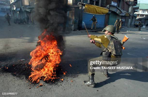 An Indian Central Reserve Police Force soldier tries to remove a burning tyre during a protest in the capital Srinagar on November 1, 2008 soon after...