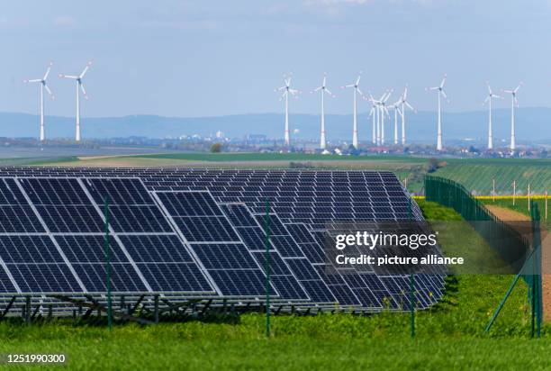 April 2023, Rhineland-Palatinate, Wahlheim: A solar farm is located in close proximity to several wind turbines. Photo: Andreas Arnold/dpa