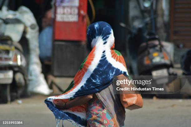 Woman covers her head and face with a dupatta in the sweltering afternoon heat as mercury rises higher in the city, in Thane, on April 19, 2023 in...