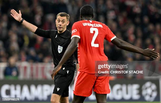 Bayern Munich's French defender Dayot Upamecano discusses with French referee Clement Turpin during the UEFA Champions League quarter-final, second...