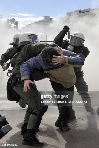 Demonstrator protects his face while clashing with riot police in Athens on March 5, 2010 during a rally against the austerity measures announced by...
