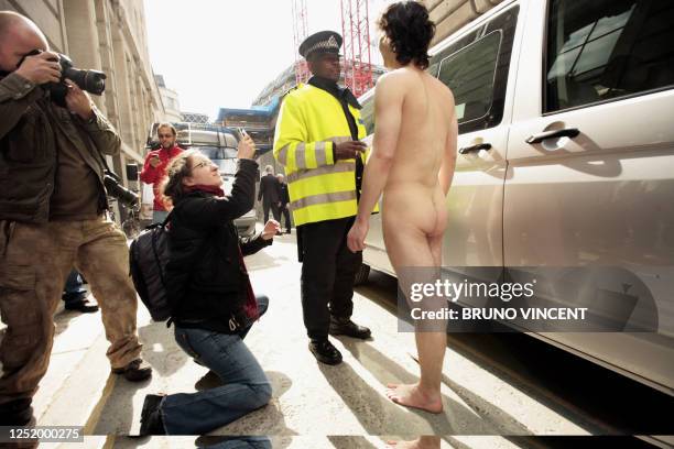 Naked man talks to a police officer near the Bank of England in London, on April 1, 2009. Angry protestors smashed through police lines and broke...
