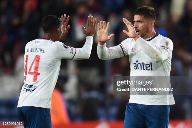 Nacional's Argentine defender Fabian Noguera celebrates with teammate midfielder Marcos Montiel after scoring a goal during the Copa Libertadores...