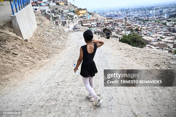 Ballet student Keith Chavez goes down the hill after performing at the San Genaro neighborhood in the Chorrillos district, south of Lima, on April 1,...