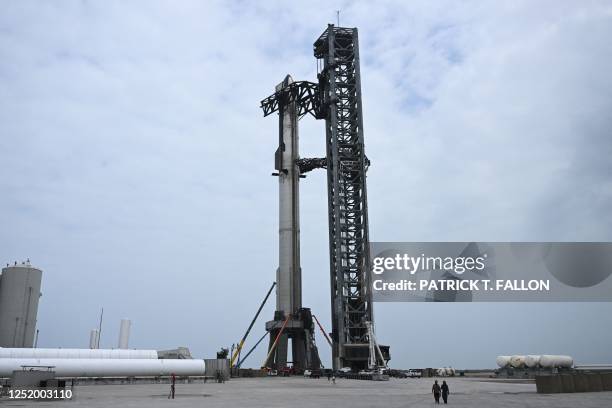 Workers in lifts prepare the SpaceX Starship ahead of the scheduled launch from the SpaceX Starbase in Boca Chica, Texas on April 19, 2023. - SpaceX...