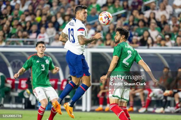 Nestor Araujo of Mexico heads the ball clear as Brandon Vazquez of United States hovers during the match at State Farm Stadium on April 19, 2023 in...