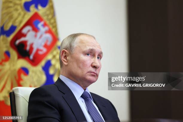 Russian President Vladimir Putin chairs a meeting with members of the government via a video conference at the Novo-Ogaryovo state residence, outside...