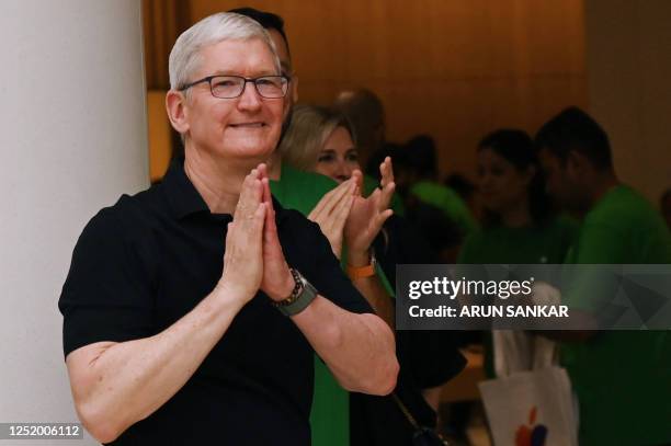 Chief Executive Officer of Apple Tim Cook gestures during the opening of New Delhi's first Apple retail store at a mall in New Delhi on April 20,...