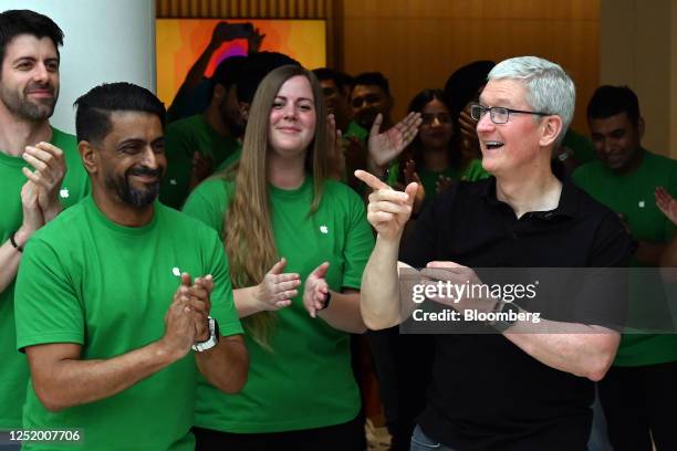 Tim Cook, chief executive officer of Apple Inc., right, greets customers during the opening of the new Apple Saket store in New Delhi, India, on...
