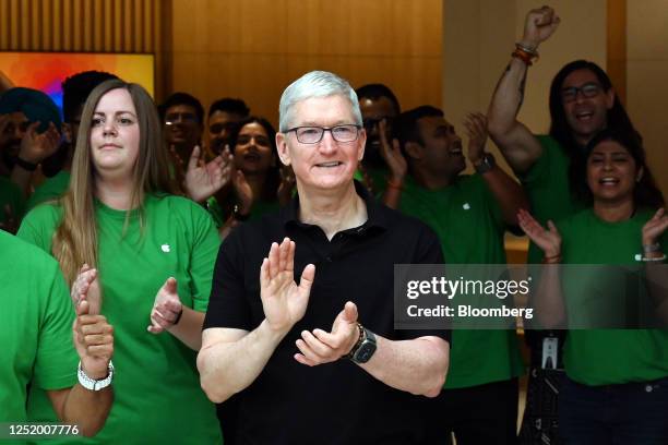 Tim Cook, chief executive officer of Apple Inc., center, greets customers during the opening of the new Apple Saket store in New Delhi, India, on...