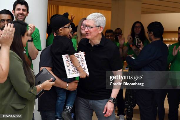 Tim Cook, chief executive officer of Apple Inc., right, greets customers during the opening of the new Apple Saket store in New Delhi, India, on...