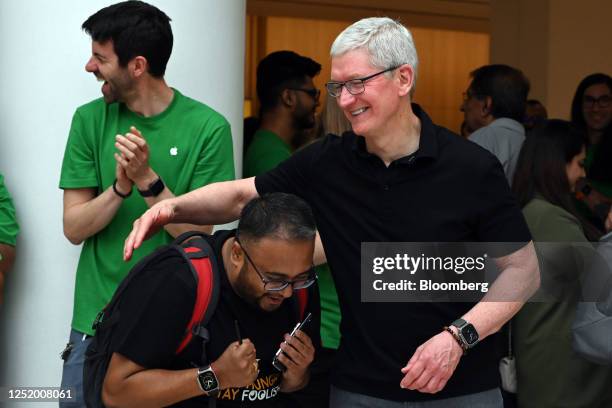 Tim Cook, chief executive officer of Apple Inc., right, greets a customer during the opening of the new Apple Saket store in New Delhi, India, on...