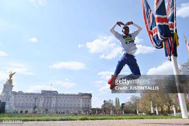 Britain's Mo Farah jumps with the Mobot pose during a photocall outside Buckingham Palace in London on April 20, 2023 ahead of the London marathon.