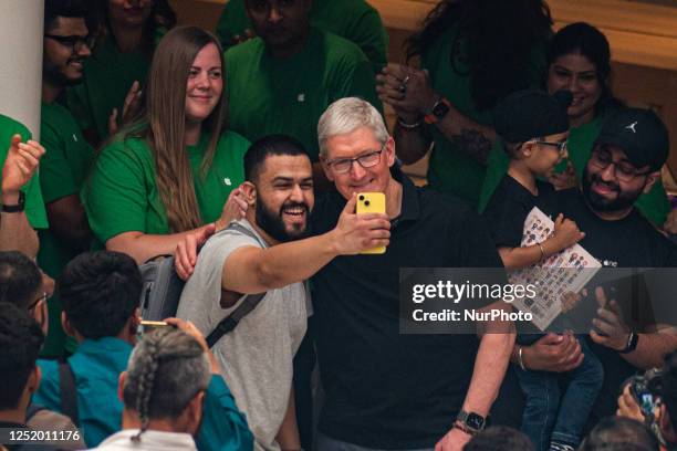 Apple Inc. Chief Executive Officer Tim Cook poses for a selfie with a fan during the launch of the new Apple Inc. Store in New Delhi, India on April...