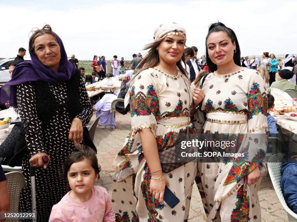 Two young women and their mother in traditional clothes participate in the Red Wednesday holiday celebration in Bacinê village. Yazidi Kurds living...