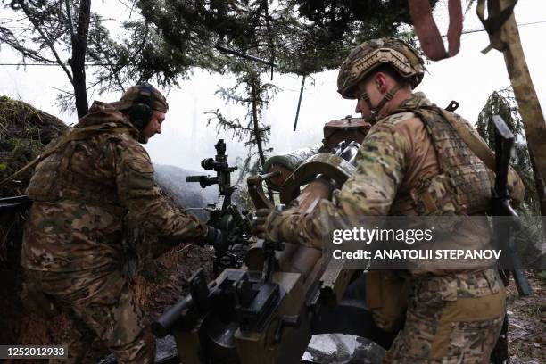 Ukrainian paratroopers fire an L119 howitzer towards Russian positions at a front line in the Lugansk region on April 20 amid the Russian invasion of...