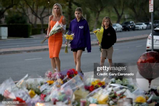 Tara Abikoff and her two children Malibu center, and Zuma visit a memorial for Wesley Welling in front of Westlake High School on Wednesday, April...