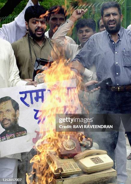 Activists from the opposition Congress-aligned "National Human Rights Council" burn phones as they shout slogans gainst Indian Telecommunications'...