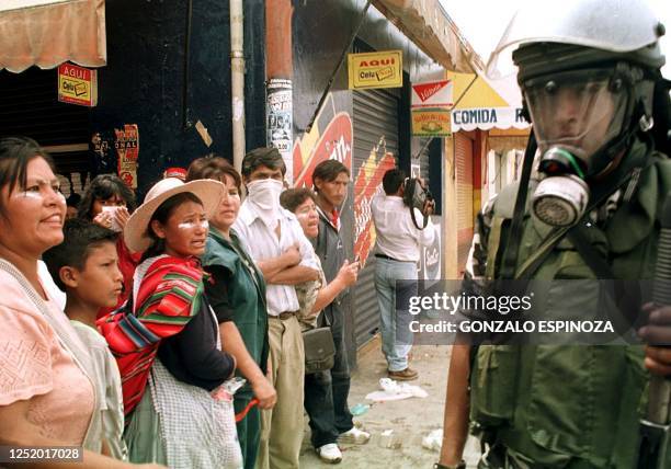 Street vendors yell at riot police 05 February in the center of Cochabamba, Bolivia, as riot police guard the main plaza from demonstrators...