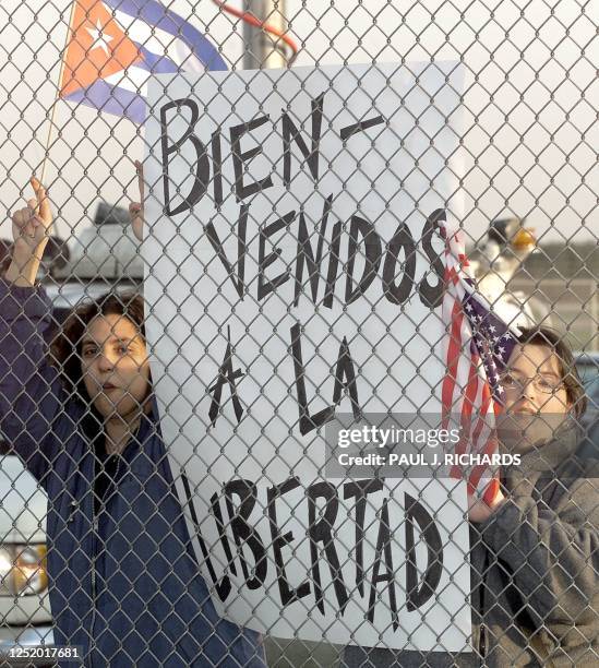 Demonstrators cheer on Juan Miguel Gonzalez, father of Cuban refugee Elian Gonzalez through a security fence 06 April, 2000 upon their arrival at...