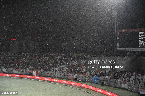 Spectators sit on the stand as a heavy hailstorm shower stops the game during the fourth Twenty20 international cricket match between Pakistan and...