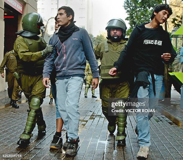 Policias anti-disturbios arrestan a unos manifestantes en las cercanias del palacio presidencial de La Moneda en Santiago, el 15 de mayo de 2004....