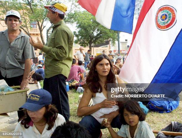 Mother breast-feeds her baby before the National Congress 05 June 2002 in Asuncion, Paraguay, during a protest against privatization and government...