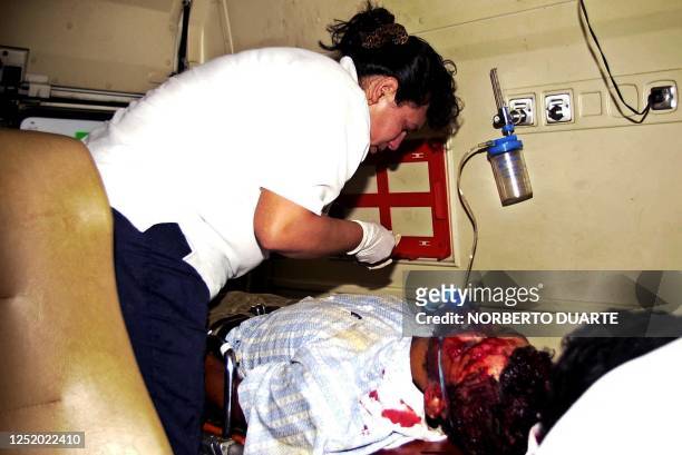 An injured demonstrator is seen being aided in an ambulance 04 June 2002 in Coronel Oviedo, Paragauy. Un campesino herido por la Policia es atendido...
