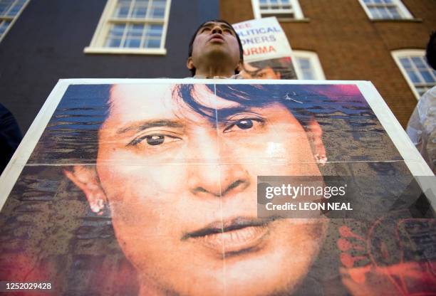 Demonstrator holds up a photograph of Myanmar democracy leader Aung San Suu Kyi during a protest outside the Myanmar embassy in central London, on...