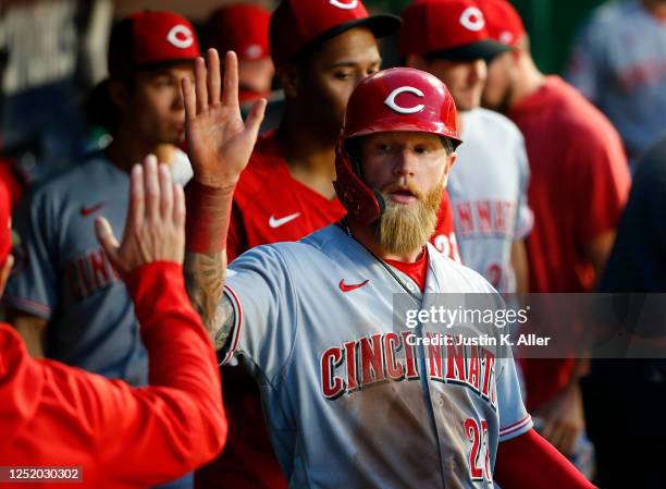 Jake Fraley of the Cincinnati Reds celebrates in the dugout after scoring on an RBI single in the seventh inning against the Pittsburgh Pirates at...