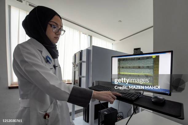 In this picture taken on March 16 laboratory technician Fatema Almahmood examines pearls by X-Ray Fluorescence at the gemmological laboratory of the...