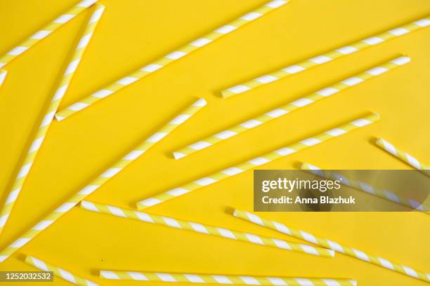 yellow and white striped paper straws. abstract summer background with drinking straws - rietje stockfoto's en -beelden