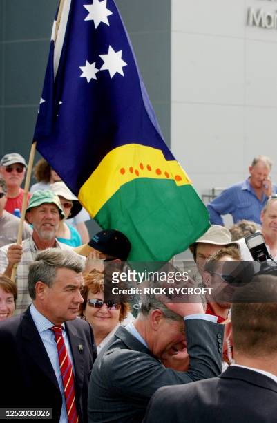 Prince Charles scratches his head after passing a republican demonstrator holding a flag outside the West Australian Maritime Museum in Fremantle, 01...