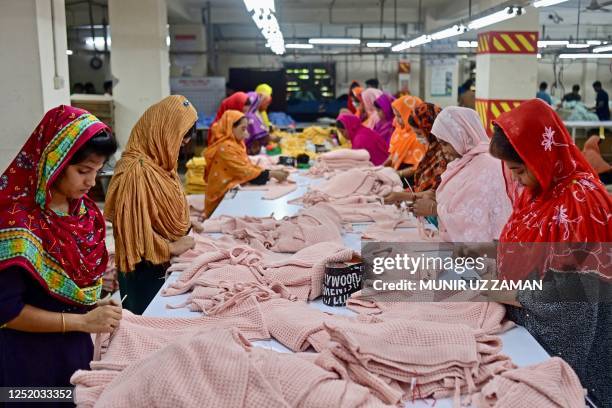 In this photograph taken on April 13 women work at a garment factory in Savar, on the outskirts of Dhaka. The tenth anniversary of the Rana Plaza...
