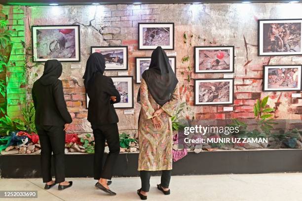 In this photograph taken on April 12 visitors look at photographs at an exhibition that marks 10 years since the Rana Plaza building collapse...