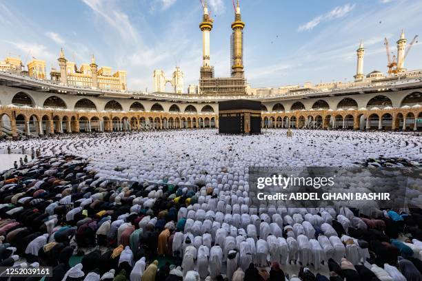 Muslim worshippers pray around the Kaaba, Islam's holiest shrine, at the Grand Mosque in the holy city of Mecca on the first day of Eid al-Fitr,...