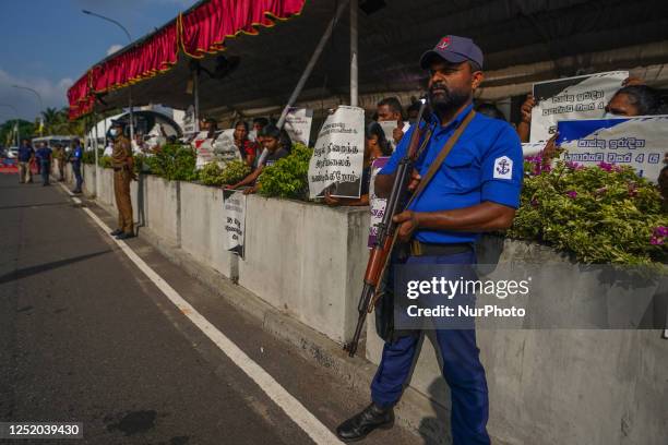 People hold placards in front of St. Anthony's shrine in Kochchikade for justice for the 2019 Easter bombing victims on April 21 in Colombo, Sri...