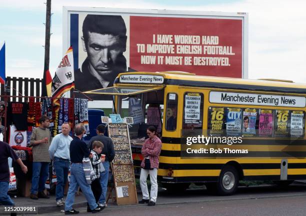 General view of souvenir stalls in front of football advertising billboards featuring Manchester United and France international Eric Cantona before...