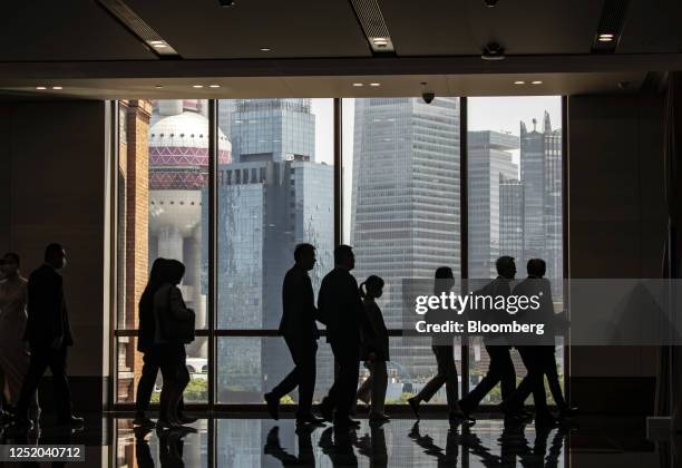 People walk past buildings in Shanghai, Shanghai, China, on Friday, April 21, 2023. The People's Bank of China signaled it may start gradually...
