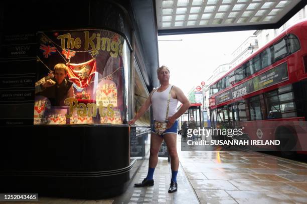David, dressed in the king's coronation pants as depicted in "The King's Pants" by Nicholas Allan, poses as the British author and illustrator paints...