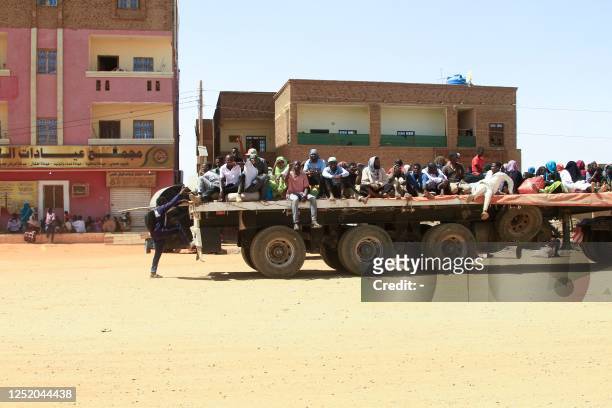People fleeing street battles between the forces of two rival Sudanese generals, are transported on the back of a truck in the southern part of...