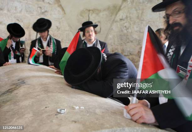 Members of Neturei Karta, a small faction of ultra-Orthodox Jews who oppose Israel's existence, hold Palestinian flags as they pray at Joseph's Tomb,...