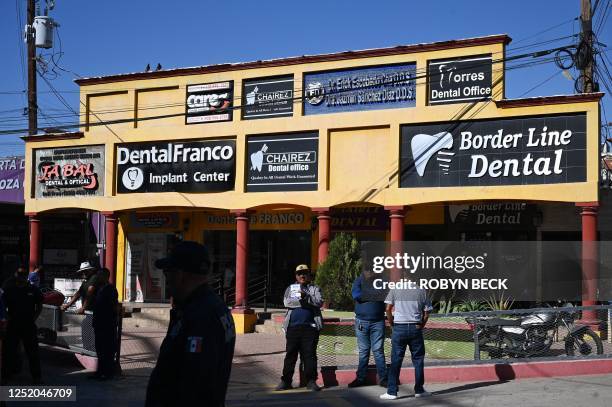 Tout holds a sign advertising dental services as he waits for American medical tourists to arrive from the border crossing checkpoint, in Los...