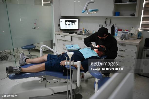 Dentist Dr Miguel Herrera installs dental implants for an American patient at the Rubio Dental Group offices in Los Algodones, Mexico, just across...