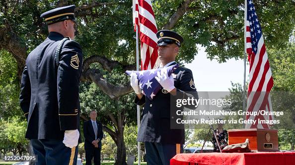 Military Rites Members of the U.S. Army Funeral Honors Team fold an American flag ...