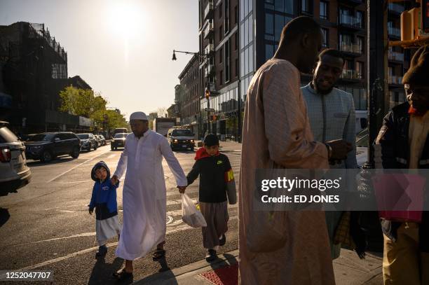 Members of the Muslim community attend prayers outside the Masjid At Taqwa during Eid al-Fitr celebrations in the Brooklyn borough of New York City...