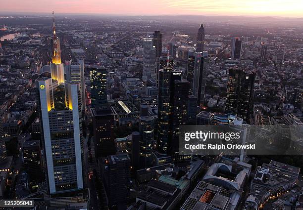 The headquarters of Commerzbank and the twin towers of Deutsche Bank stand illuminated amid the skyline in this aerial picture of the financial...